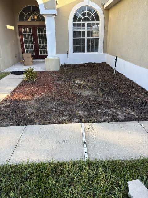 Before: bare, weedy flower bed by the front entry