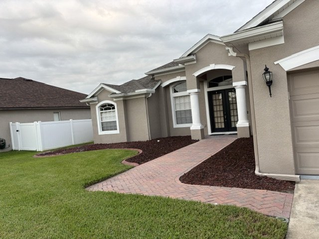 Front lawn with crisp edged mulch beds along a brick walkway
