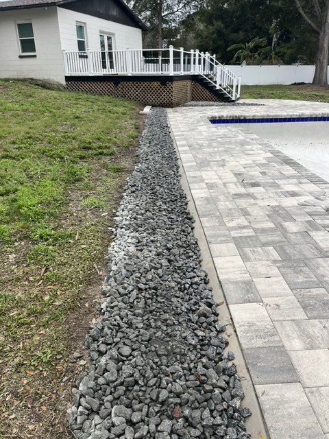Rock border installed along a paver pool deck